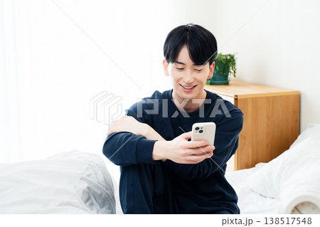 ベッドでスマホを見る若い男性 138517548