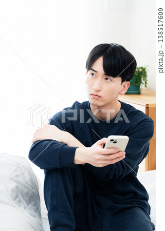 ベッドでスマホを見る若い男性 138517609