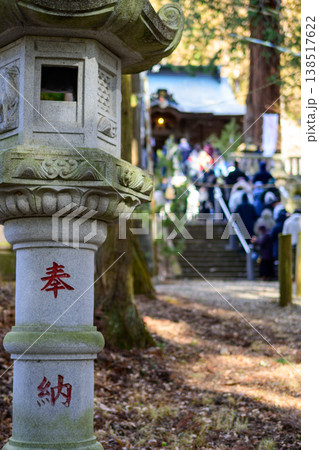 神社の境内に佇む石灯籠と参拝客で賑わう冬の初詣風景 神社の境内に佇む石灯籠と参拝客で賑わう冬の初詣風景 138517622