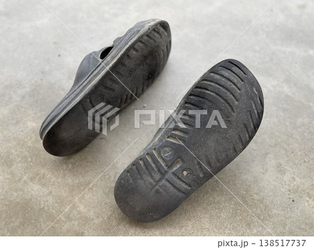 Pair Of Worn Black Rubber Shoes On Ground Pair Of Worn Black Rubber Shoes On Ground 138517737