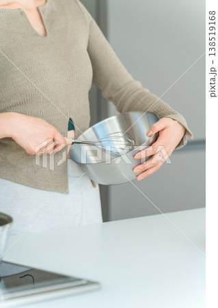キッチンでボウルと泡立て器を使い調理する女性の手元 138519168