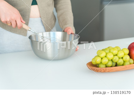 キッチンでボウルと泡立て器を使い調理する女性の手元 138519170