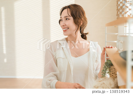 ほこり取り,ウールダスターで収納棚の埃を払う女性 138519343