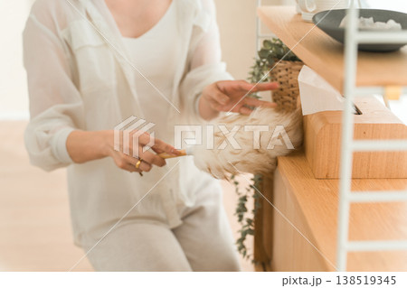 ほこり取り,ウールダスターで収納棚の埃を払う女性 138519345
