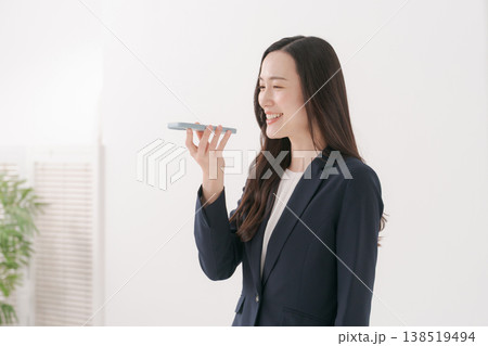 スマホで音声入力をする女性 138519494