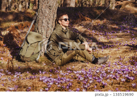 Man Hiker Sitting in Forest with Crocus Flowers Man Hiker Sitting in Forest with Crocus Flowers 138519690