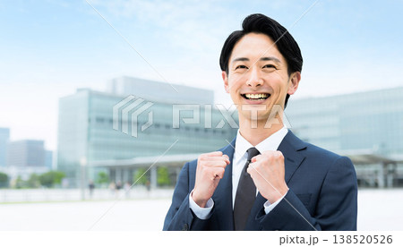 ガッツポーズで笑顔の日本人ビジネスマン（屋外・オフィス街） 138520526