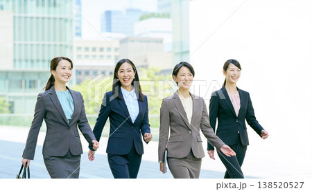 笑顔でオフィス街を歩くスーツ姿の日本人ビジネスウーマン4人組 138520527