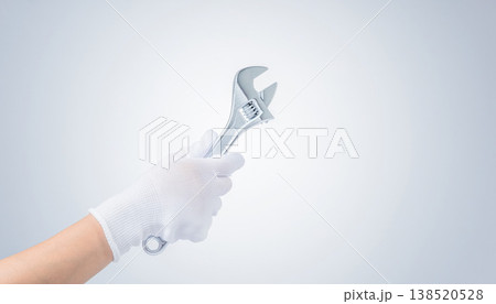 モンキーレンチを持つ作業員の右手（白手袋・クローズアップ） 138520528