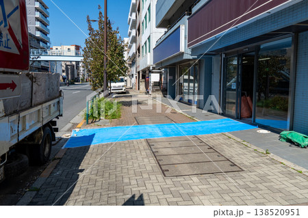 歩道を保護するために敷かれた養生用のブルーシート 歩道を保護するために敷かれた養生用のブルーシート 138520951