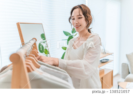 ハンガーラックから洋服を選ぶアジア人女性(衣装合わせ,コーディネート,着替え,身支度) ハンガーラックから洋服を選ぶアジア人女性(衣装合わせ,コーディネート,着替え,身支度) 138521057