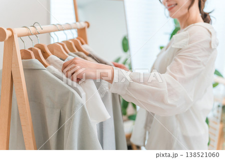 ハンガーラックから洋服を選ぶアジア人女性（衣装合わせ,コーディネート,着替え,身支度） 138521060