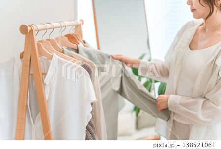 ハンガーラックから洋服を選ぶアジア人女性（ショッピング,コーディネート,セール,買い物） 138521061