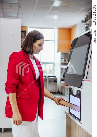 woman returning book at self service library machine looking at camera with confident slight smile in modern library interior professional librarian scene, education, library service woman returning book at self service library machine looking at camera with confident slight smile in modern library interior professional librarian scene, education, library service 138521205