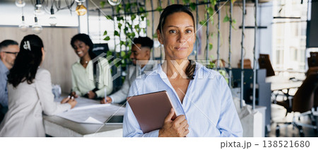 Manager reviewing project milestones amidst modern office setting Manager reviewing project milestones amidst modern office setting 138521680
