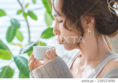 リビングでモーニングコーヒー,ホットドリンク,スープを飲むおしゃれなアジア人女性 138521690