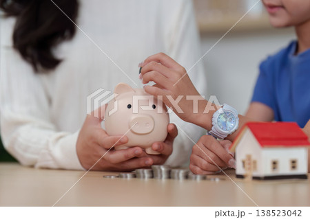 Child Saving Money in Piggy Bank Child Saving Money in Piggy Bank 138523042
