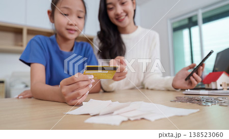 Mother teaching child financial literacy at home 138523060