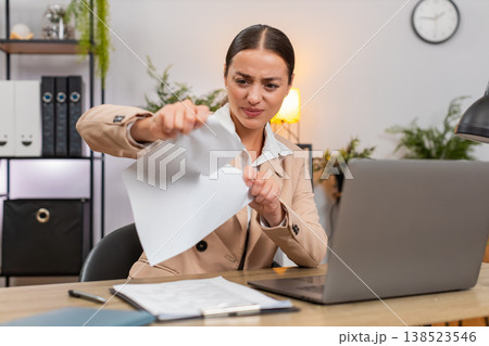 Young businesswoman rips error draft report opens new document and starts fast typing on laptop fast 138523546