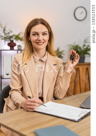 Businesswoman holds keys for new room signs contract paper smiles shows keychain starts new chapter Businesswoman holds keys for new room signs contract paper smiles shows keychain starts new chapter 138523555