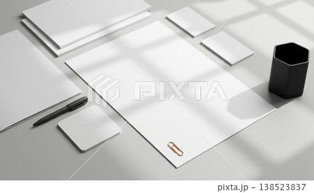 Workspace setup with blank papers a pen notepads and a cup in a room with soft light from the window in the morning 138523837