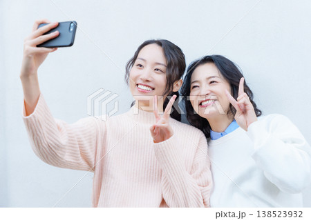 縁側でスマホ自撮りする仲良し母娘のポートレート 縁側でスマホ自撮りする仲良し母娘のポートレート 138523932