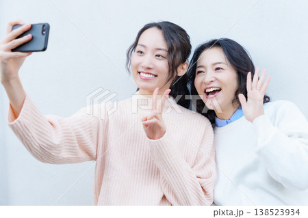 縁側でスマホ自撮りする仲良し母娘のポートレート 縁側でスマホ自撮りする仲良し母娘のポートレート 138523934