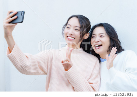 縁側でスマホ自撮りする仲良し母娘のポートレート 縁側でスマホ自撮りする仲良し母娘のポートレート 138523935