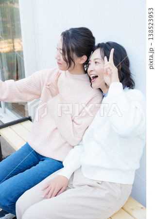 縁側でスマホ自撮りする仲良し母娘のポートレート 138523953