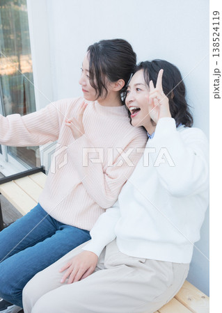 レトロ感のある縁側でスマホ自撮りする仲良し母娘のポートレート 138524119