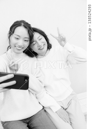 縁側でスマホ自撮りする仲良し母娘のモノクロポートレート 縁側でスマホ自撮りする仲良し母娘のモノクロポートレート 138524293