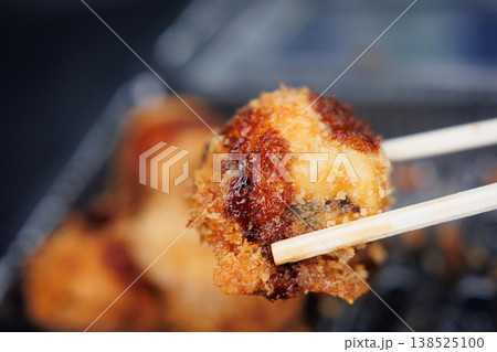 箸で持った揚げたこ焼き 箸で持った揚げたこ焼き 138525100