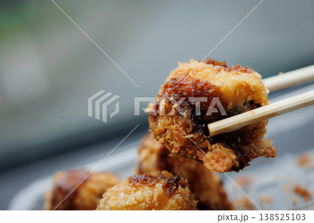 箸で持った揚げたこ焼き 138525103