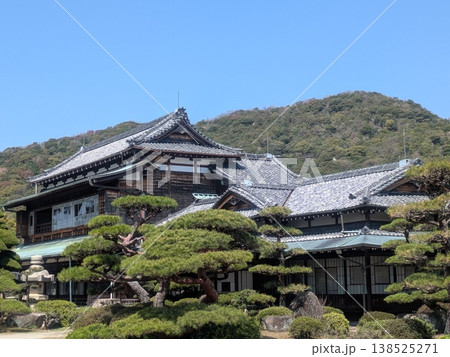 和風建築と松の庭園が広がる日本家屋、青空と山を背景にした風景素材 138525271