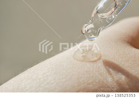 Skincare serum dropping on skin, providing hydration and essential care for beauty Skincare serum dropping on skin, providing hydration and essential care for beauty 138525353
