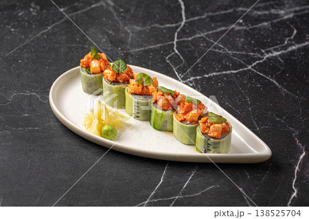 Sushi rolls wrapped in cucumber with spicy topping 138525704