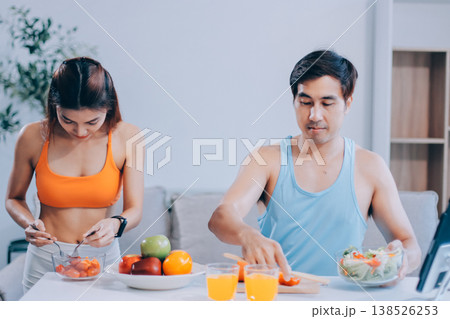 A happy couple prepares fresh vegetables, laughing and enjoying cooking a healthy meal together. A happy couple prepares fresh vegetables, laughing and enjoying cooking a healthy meal together. 138526253