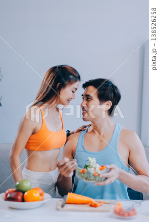 A happy couple prepares fresh vegetables, laughing and enjoying cooking a healthy meal together. A happy couple prepares fresh vegetables, laughing and enjoying cooking a healthy meal together. 138526258