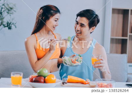 A happy couple prepares fresh vegetables, laughing and enjoying cooking a healthy meal together. A happy couple prepares fresh vegetables, laughing and enjoying cooking a healthy meal together. 138526264