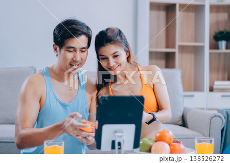A happy couple prepares fresh vegetables, laughing and enjoying cooking a healthy meal together. 138526272