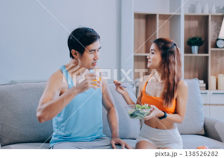 A happy couple prepares fresh vegetables, laughing and enjoying cooking a healthy meal together. 138526282