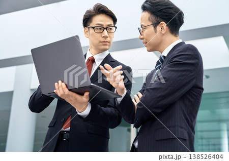 オフィスでノートパソコンを使い打ち合わせをする日本人ビジネスマンの二人 138526404