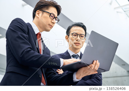 ノートパソコンを見ながら真剣に話し合う2人の日本人ビジネスマン 138526406