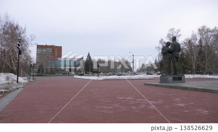 March 22 2026 Barnaul Russia Farewell monument genre sculpture memorial with view of Mir Cinema covered in snow cold early spring urban cityscape and winter atmosphere. March 22 2026 Barnaul Russia Farewell monument genre sculpture memorial with view of Mir Cinema covered in snow cold early spring urban cityscape and winter atmosphere. 138526629