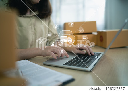 Woman Using Laptop for Online Shopping and Express Delivery Services with Delivery Icons and Brown Boxes in Modern Home Office Setting 138527227