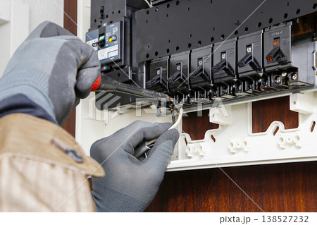 分電盤の点検やブレーカー交換を行う電気工事士の手元 作業風景 イメージ 138527232