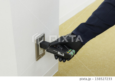 コンセントの電気設備点検・動作確認を行う電気工事士の手元 作業風景 イメージ 138527233