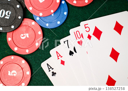 1 Pair Combination playing cards spread beside casino chips on green felt gambling table 1 Pair Combination playing cards spread beside casino chips on green felt gambling table 138527258