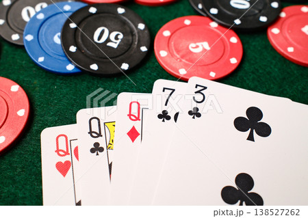 3 Of A Kind Combination Playing cards spread beside casino chips on green felt gambling table 3 Of A Kind Combination Playing cards spread beside casino chips on green felt gambling table 138527262