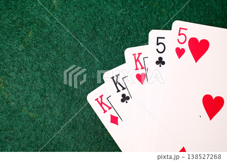 Full House Combination Playing cards arranged on dark green felt casino gambling table closeup detail Full House Combination Playing cards arranged on dark green felt casino gambling table closeup detail 138527268